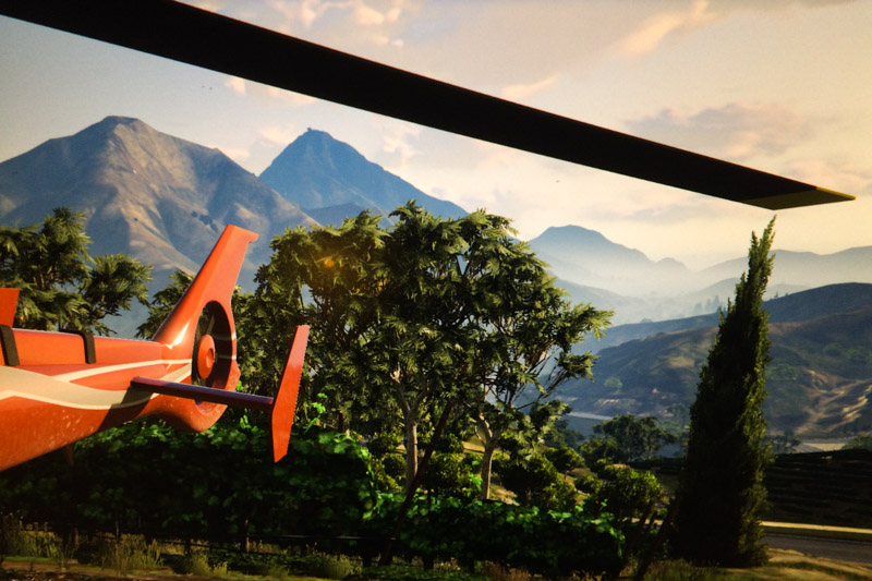 A view of a landscape with the tail and main rotor of a landed helicopter in the foreground.