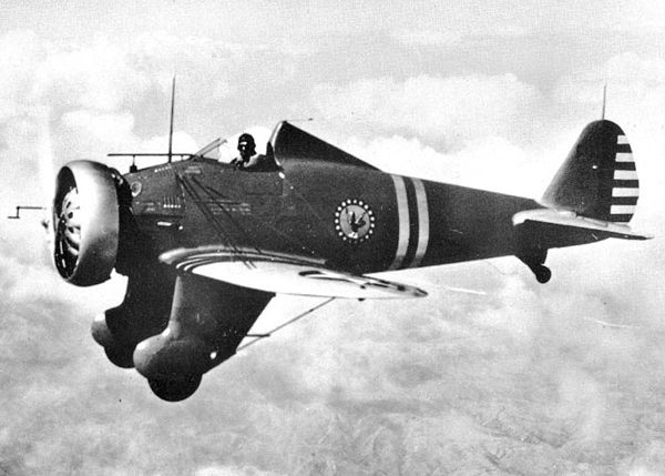 A black and white photograph of a Boeing P-26 Peashooter in flight.